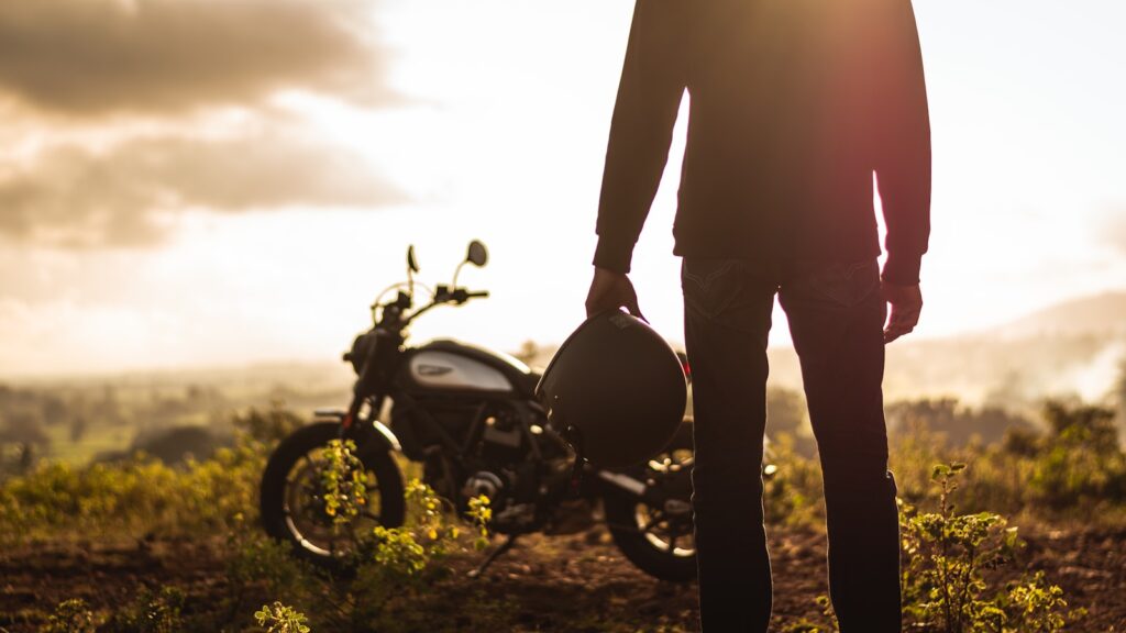a person standing next to a motorcycle