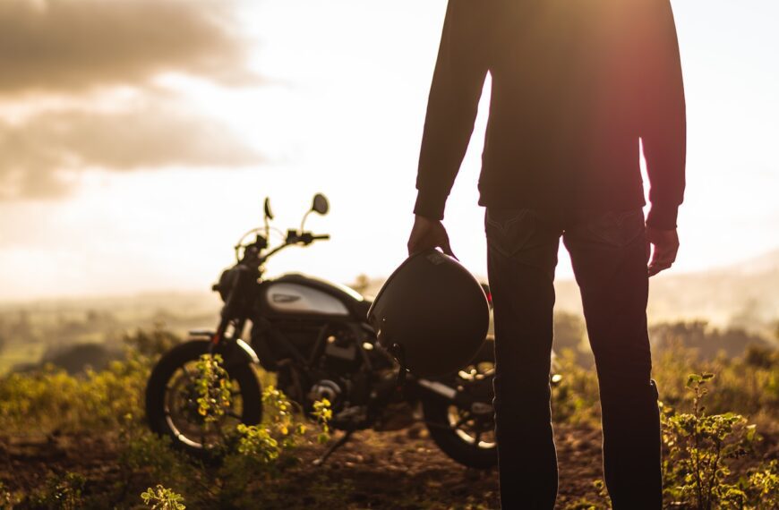 a person standing next to a motorcycle