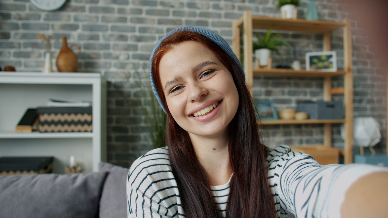 Young woman smiling and taking a selfie indoors