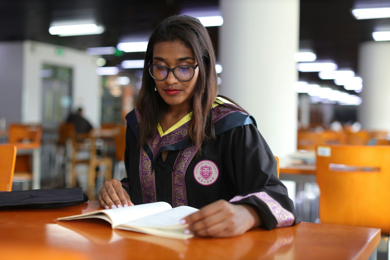 A woman sitting at a table in front of a laptop computer