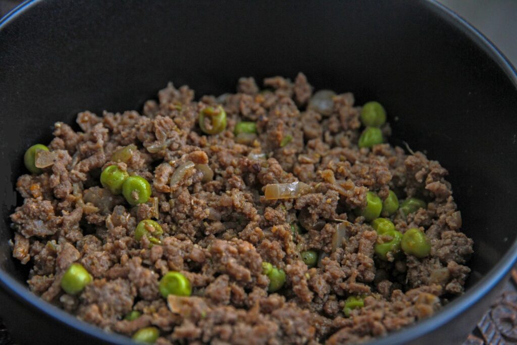 Close-up of a savory dish with minced meat and peas, ideal for culinary themes.