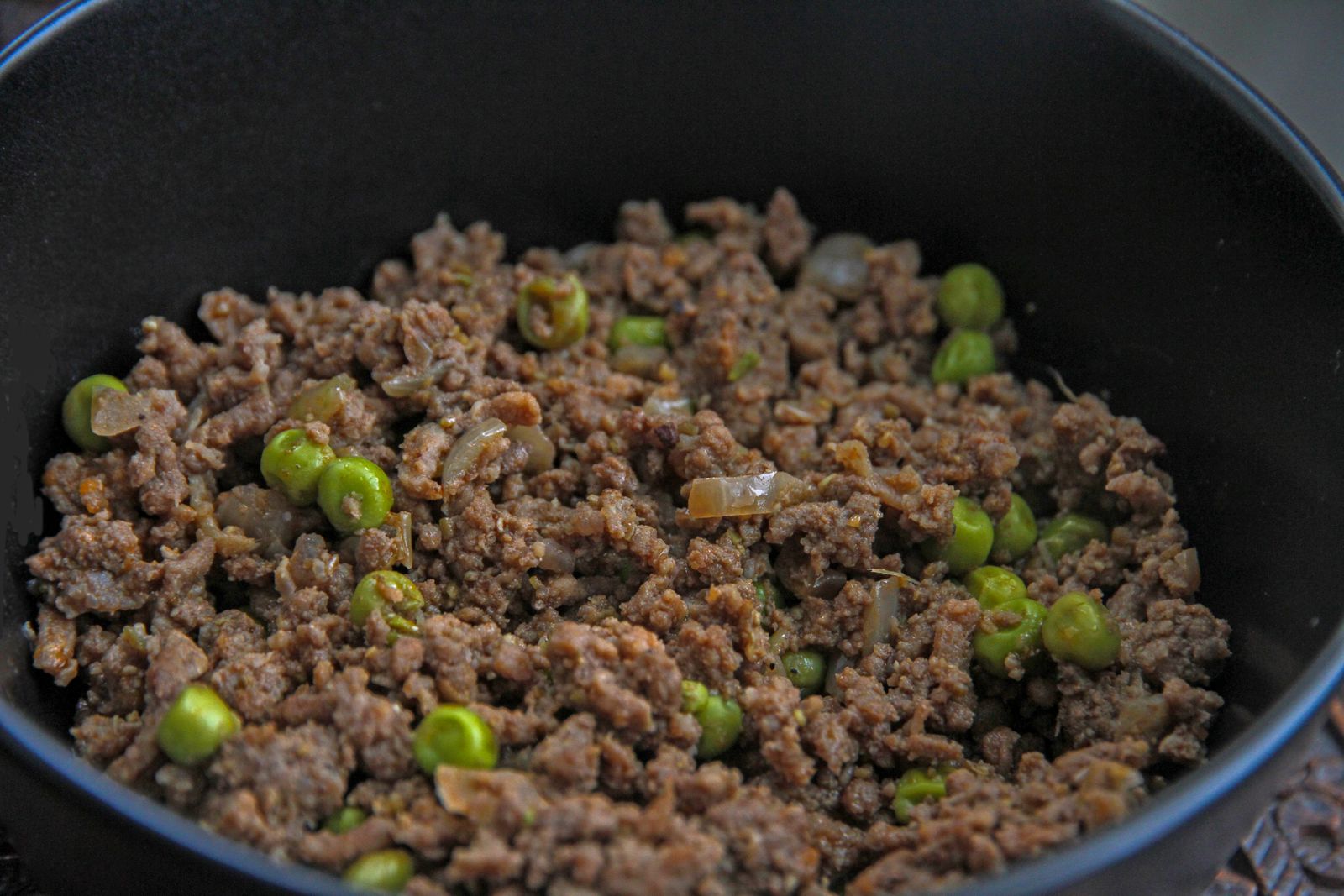 Close-up of a savory dish with minced meat and peas, ideal for culinary themes.