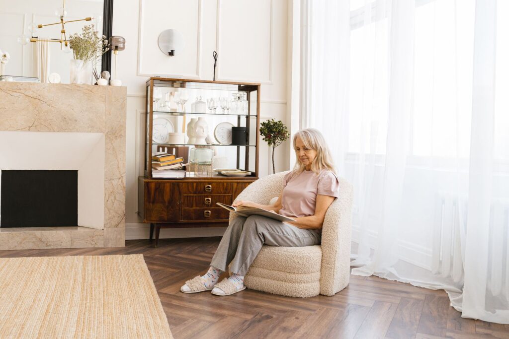 Senior woman enjoys quiet reading in a cozy, modern living room with elegant decor.