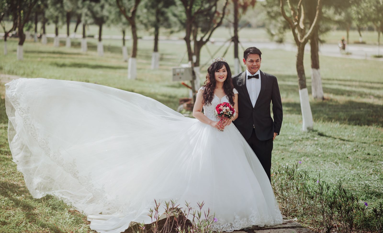 A charming outdoor wedding portrait of a smiling bride and groom on a sunny day.
