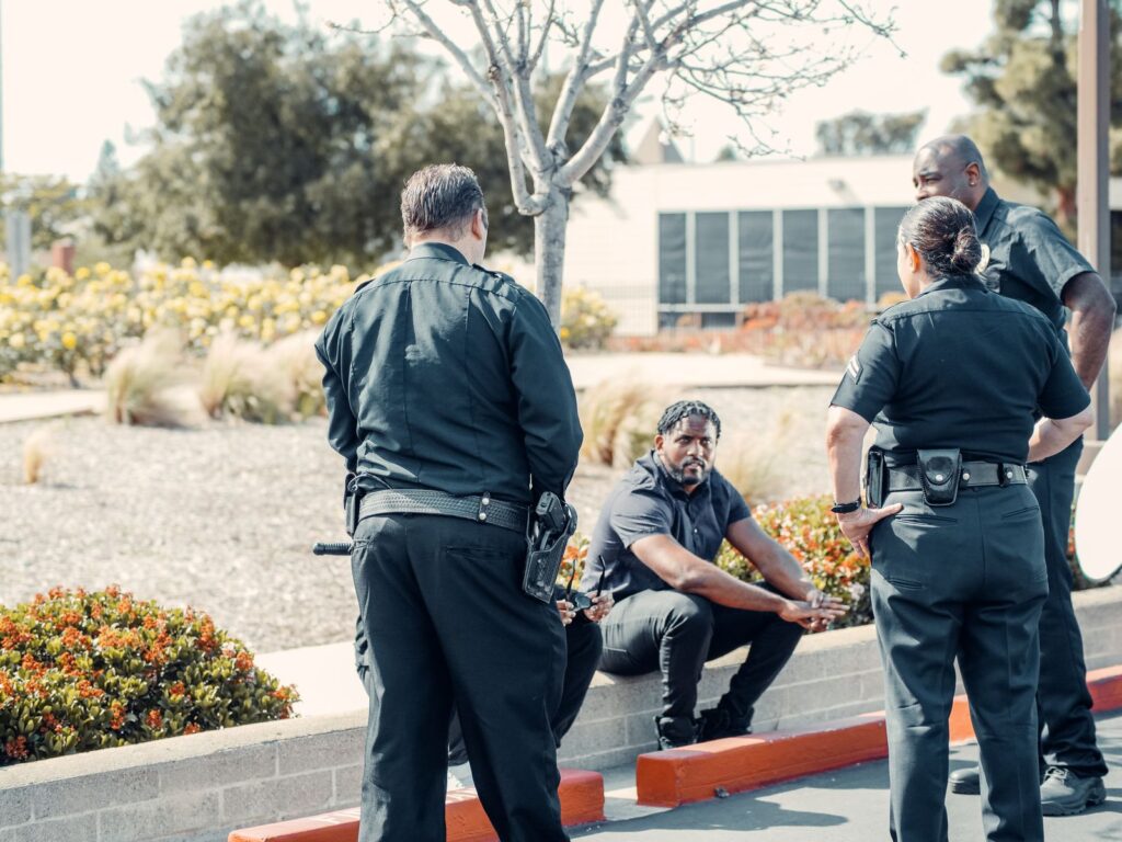 Law enforcement officers interacting with a person outdoors, displaying cooperation and safety enforcement.
