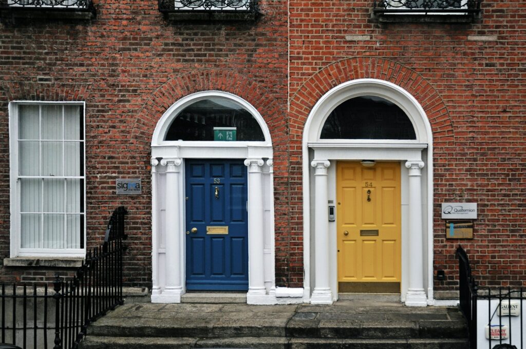 Two colorful doors on a brick building