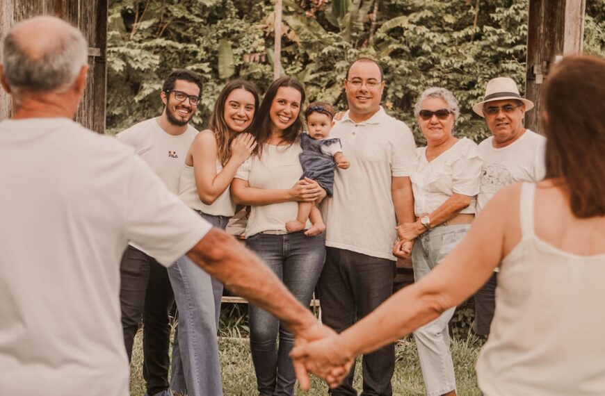 a group of people holding hands in front of trees