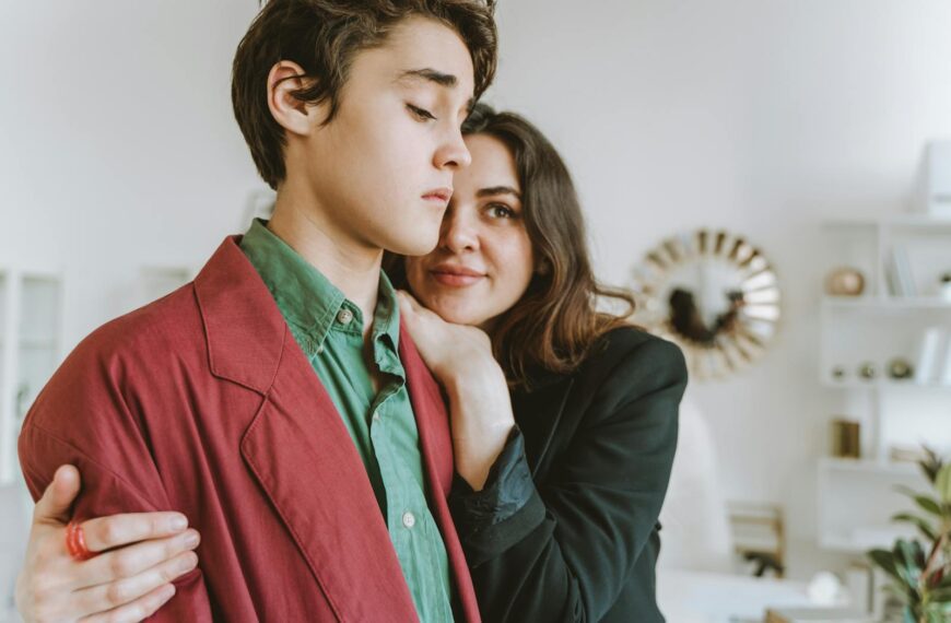 Fashionable young individuals embracing indoors, expressing warmth and style.