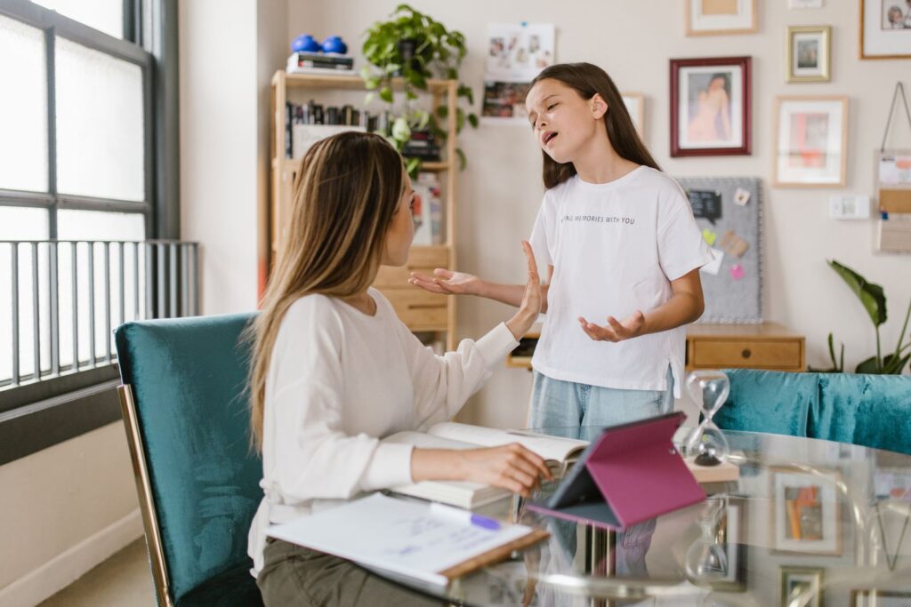 A mother and daughter engage in a meaningful conversation in a cozy home office setting.