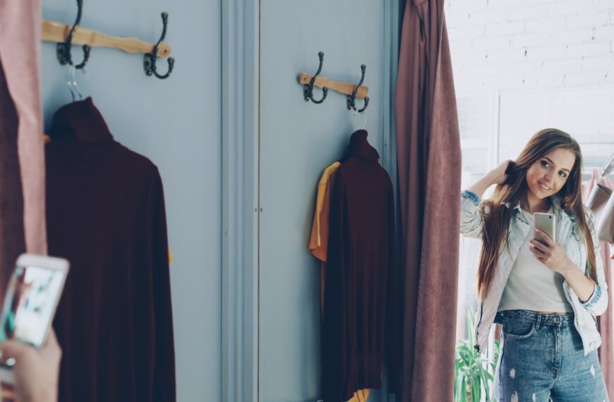 Woman takes a selfie in a clothing store's changing room.