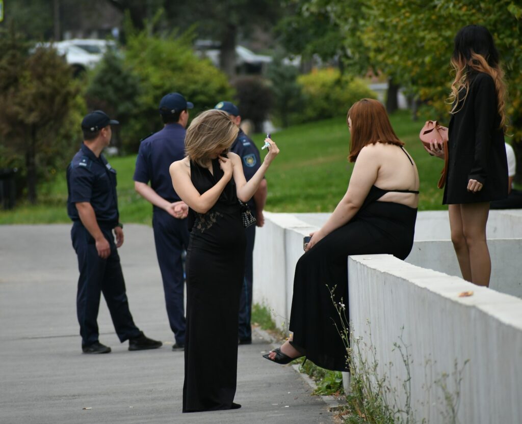 People in formal attire interacting near uniformed officers