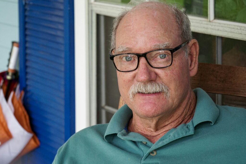 man in green polo shirt wearing black framed eyeglasses
