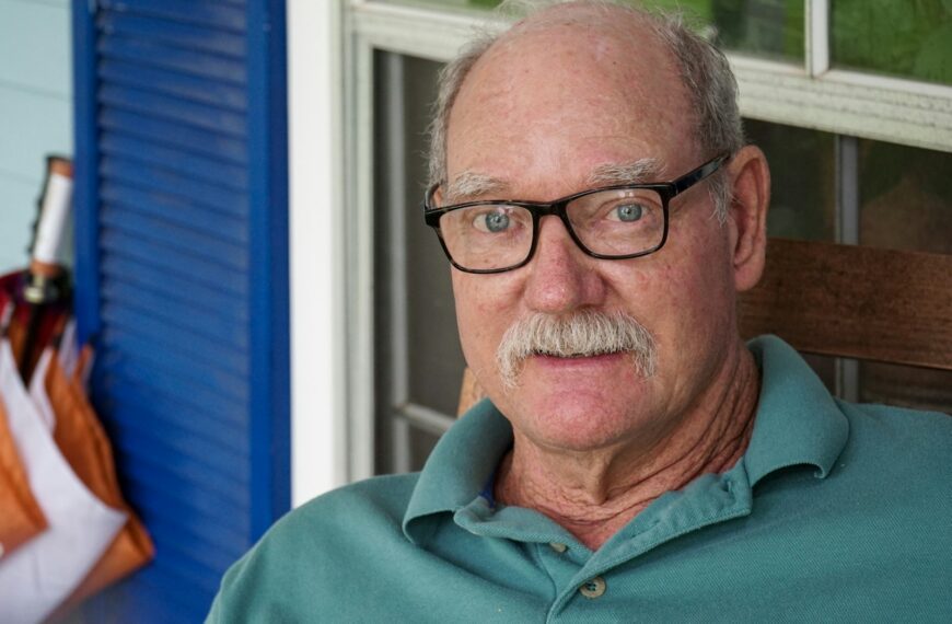 man in green polo shirt wearing black framed eyeglasses