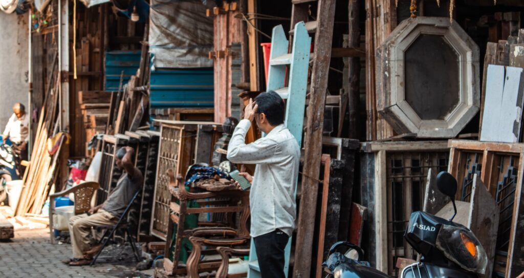 Man looking through binoculars at cluttered market stall