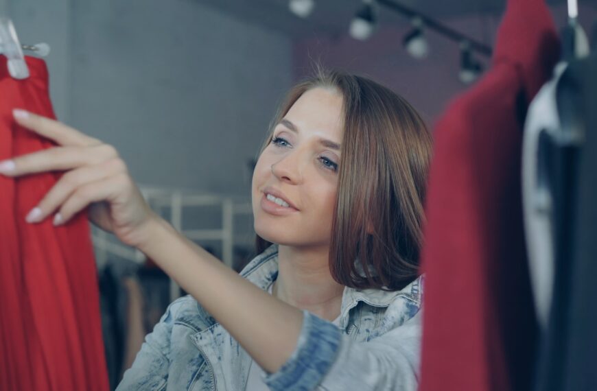 Woman browses clothing on a clothing rack.