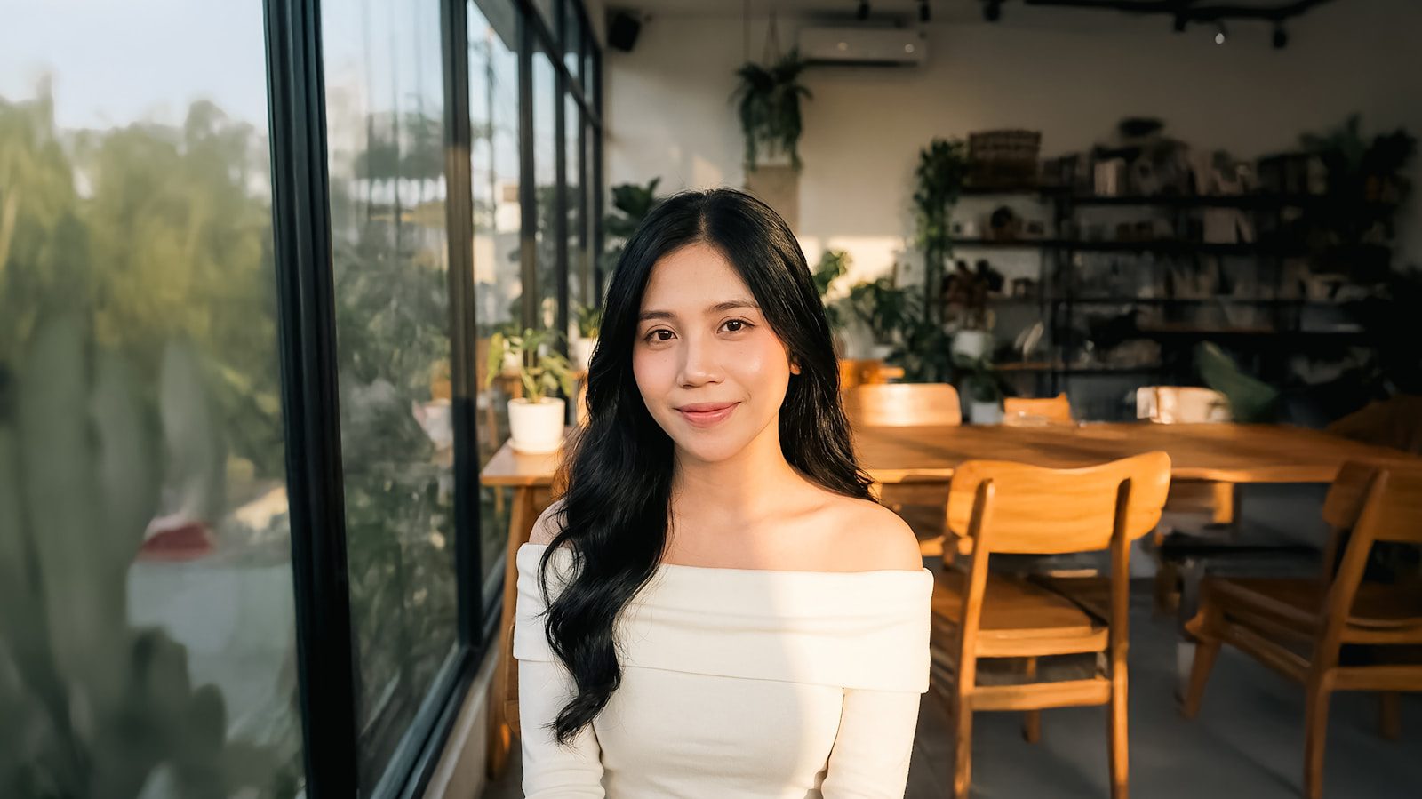Young woman smiling in a cafe with plants