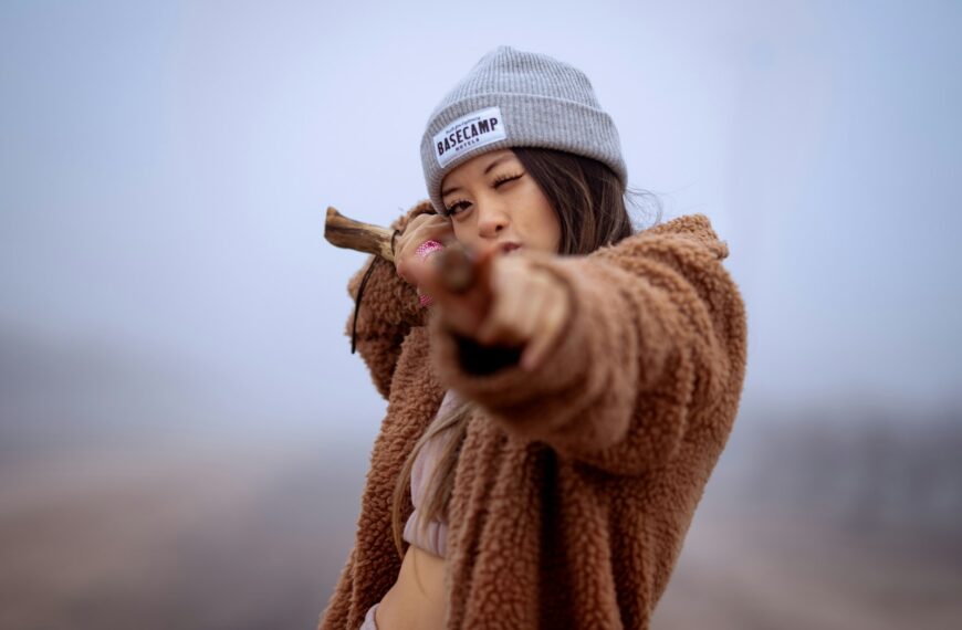a woman wearing a hat and holding a baseball bat