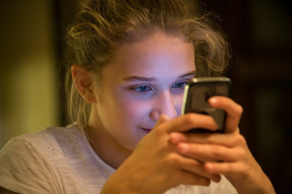 woman in gray top using smartphone