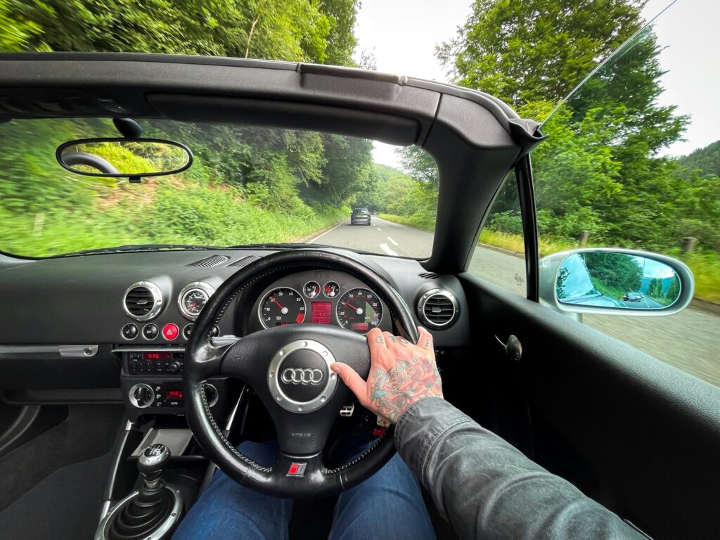 person in blue denim jeans driving car