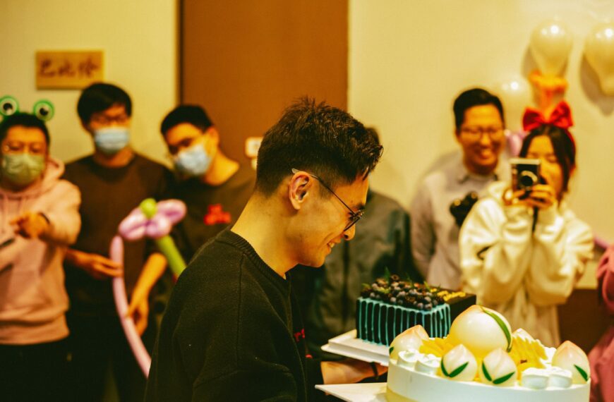 a group of people standing around a cake