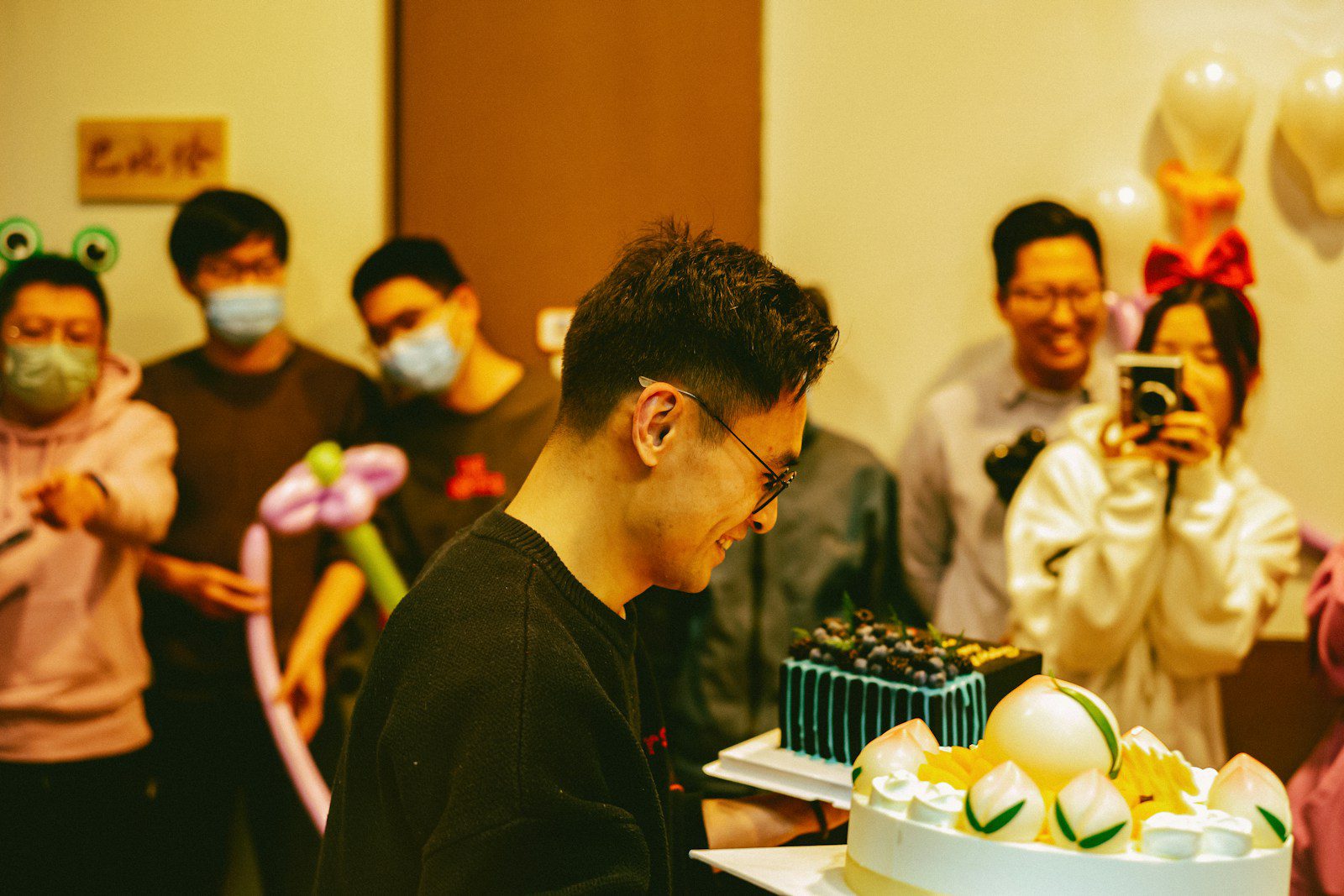 a group of people standing around a cake