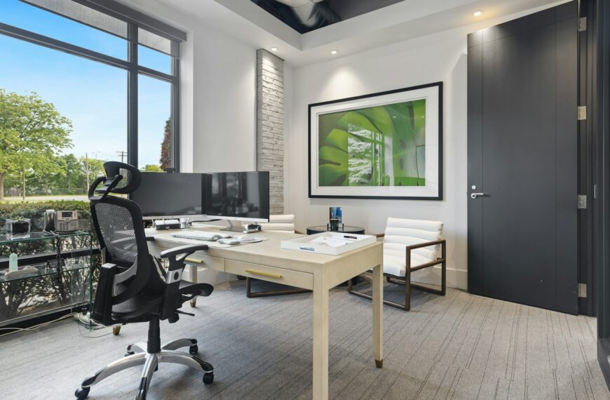a room with a desk and chairs