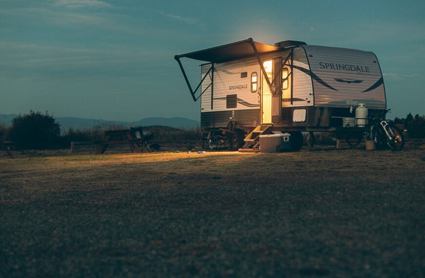 a small camper sits in a field at night