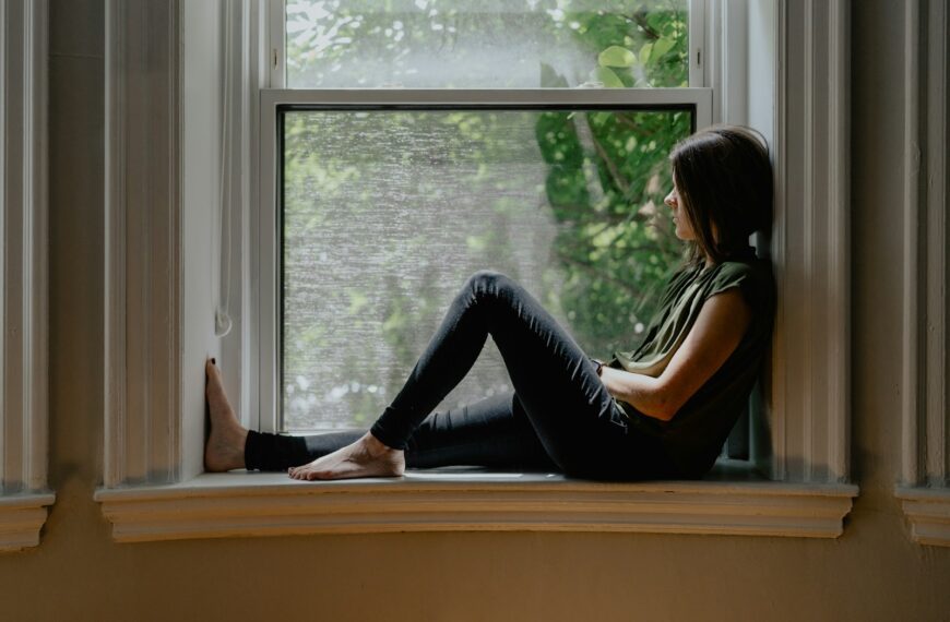 a woman sitting on a window sill