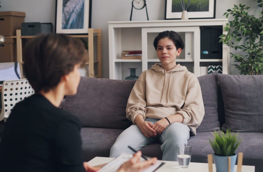 a woman sitting on a couch talking to another woman