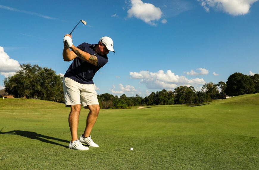 man in black shirt and white shorts playing golf during daytime