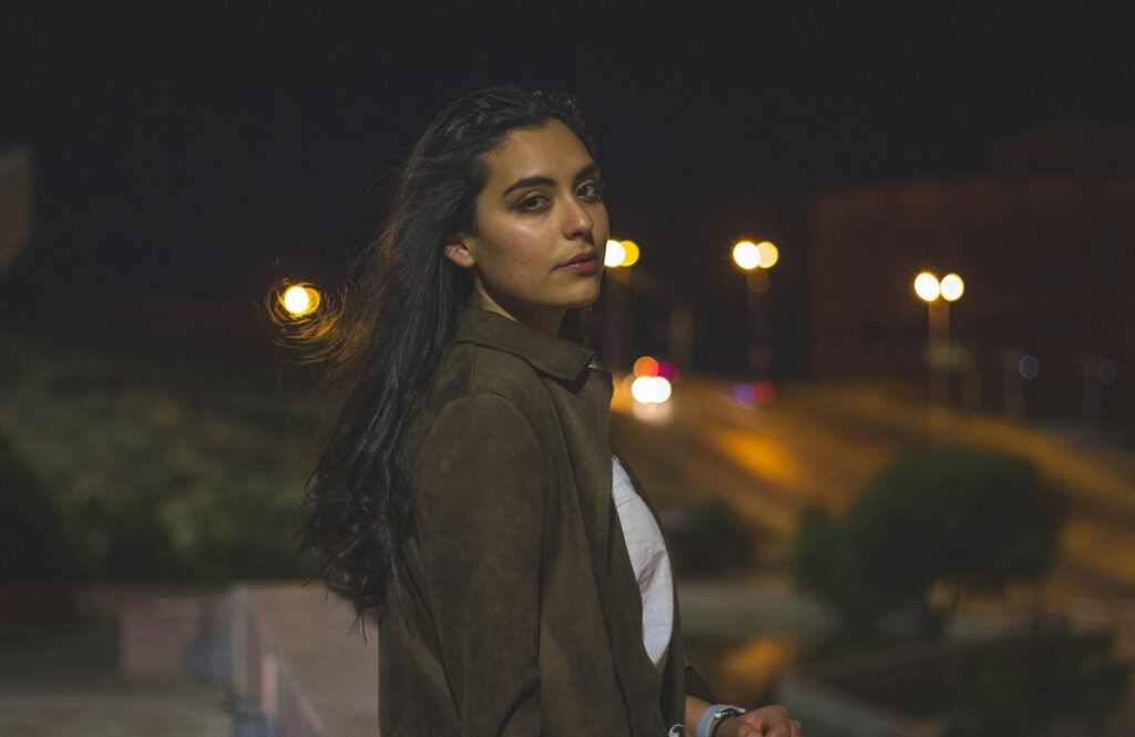 woman in black jacket standing during night time