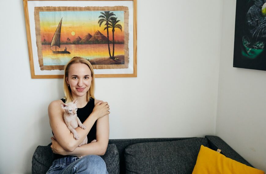 Woman holding a small cat on a couch