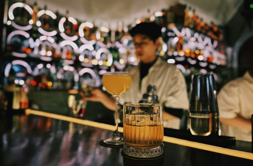 a man sitting at a bar with a drink in front of him
