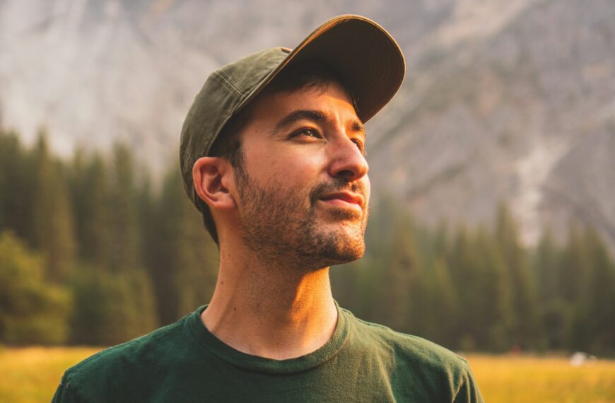 man in green crew neck shirt and black hat