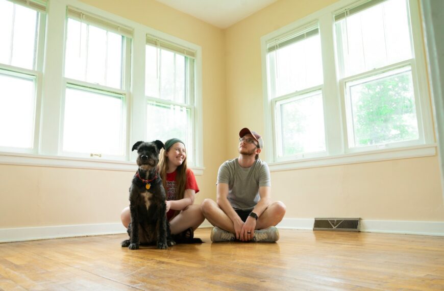 woman in gray shirt sitting on brown wooden floor