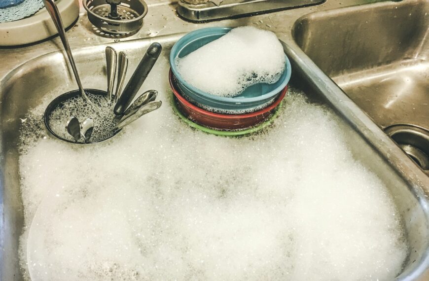 stainless steel spoons on white ceramic sink