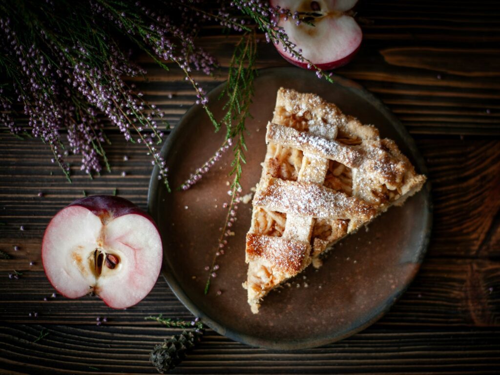 Slice of apple pie with fresh apples and lavender