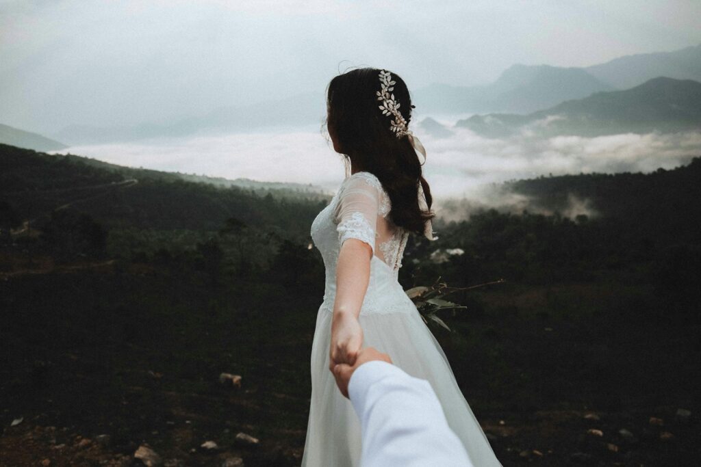 woman at the peak of the mountain holding hands