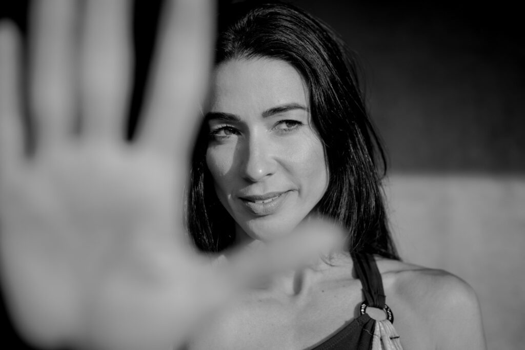 Woman holding hand up in black and white.