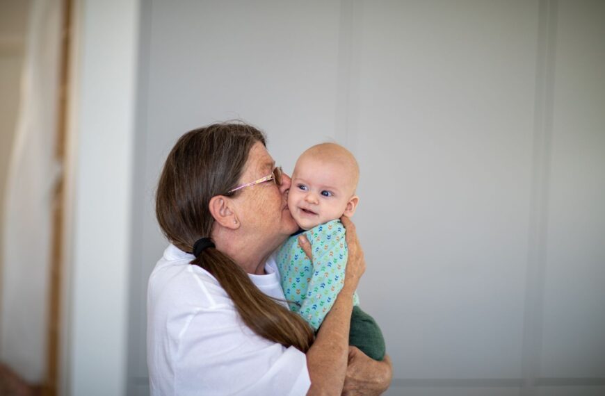 A joyful moment between a loving grandmother and her smiling grandchild indoors.