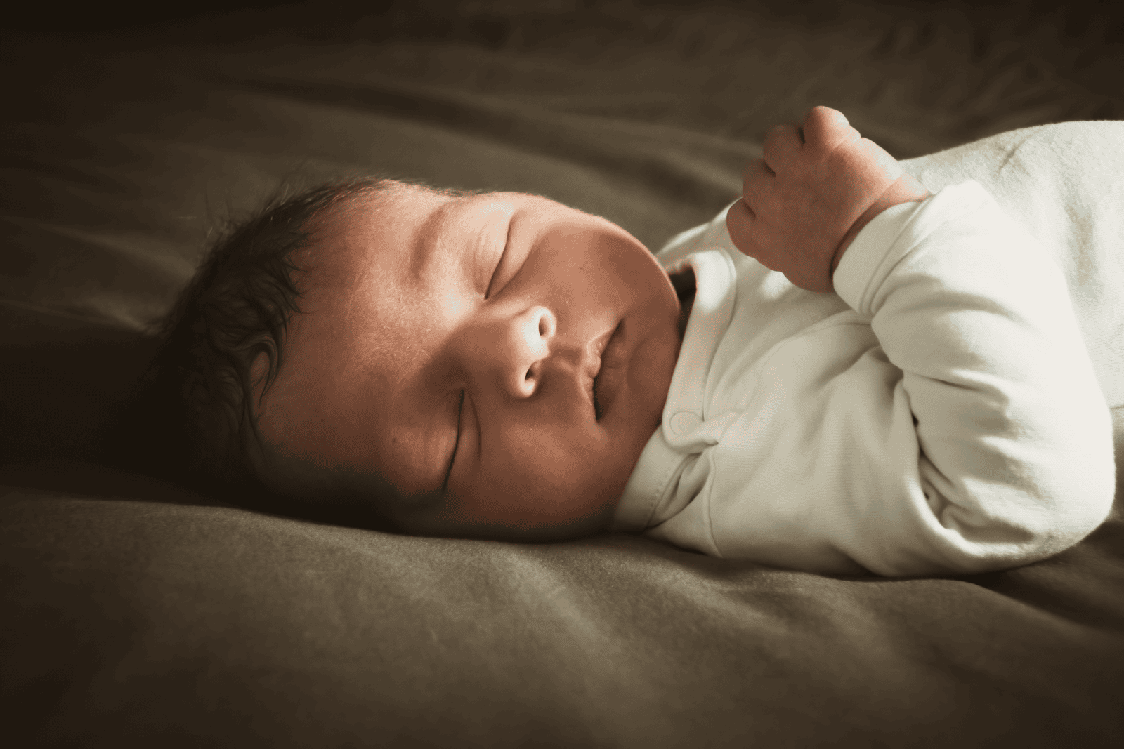 Close-up of a newborn sleeping peacefully indoors with soft lighting. Ideal for lifestyle and family themes.