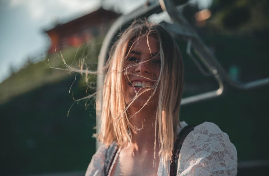 Cheerful woman in dirndl enjoying a sunny day in Kitzbühel, Austria.