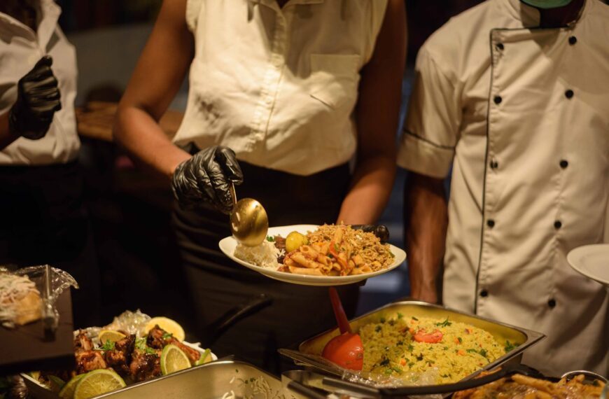 Catering service in Enugu, Nigeria with delicious buffet offerings served by staff.