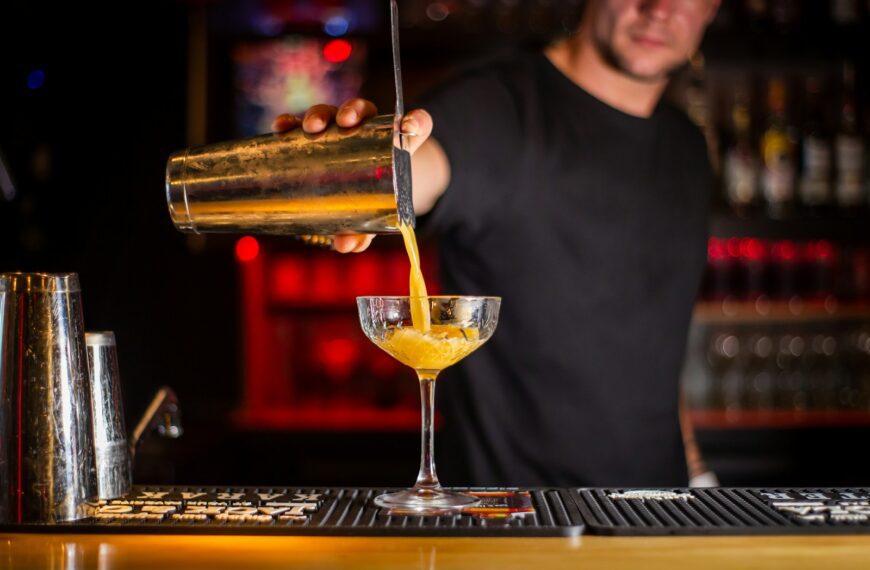man in black crew neck shirt holding clear wine glass