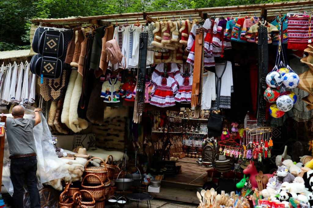 a man standing in front of a store filled with lots of items