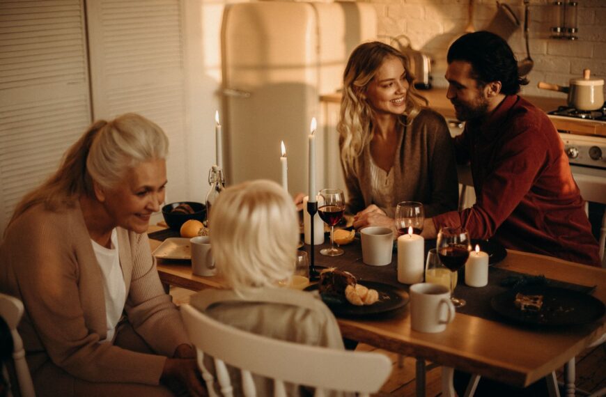 Warm family dinner setting with candles, wine, and togetherness in an inviting indoor space.