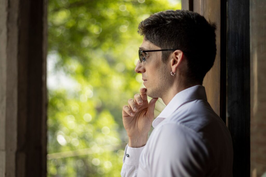 Side profile of a man in sunglasses contemplating by a window in Buenos Aires, Argentina