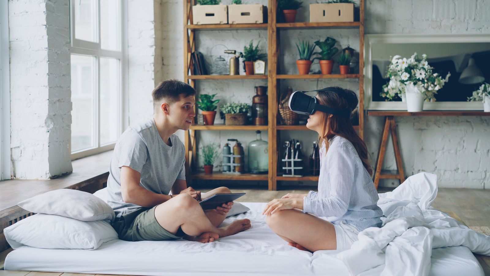 Young couple engaged with virtual reality and technology indoors.