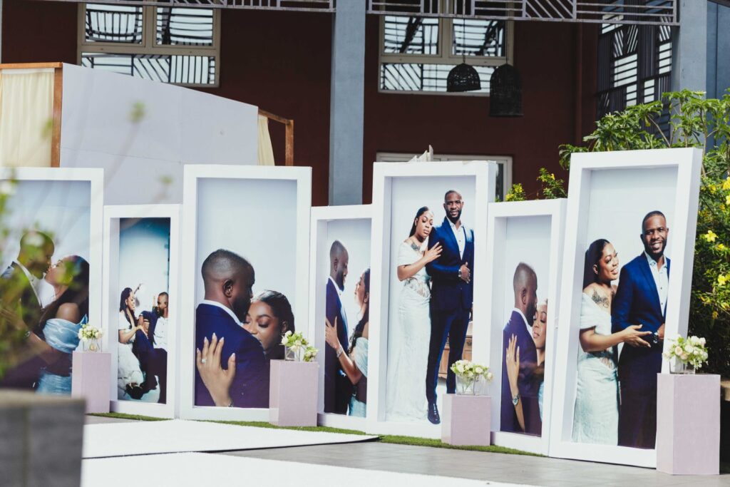 Large portrait displays at an African outdoor wedding showcasing a couple's special moments.