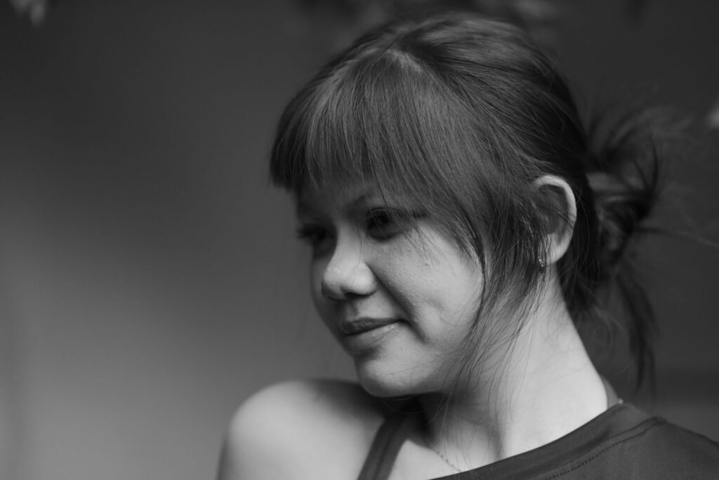 A black and white portrait capturing the serene expression of a woman looking away.